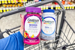 hand holding two bottles of centrum vitamins