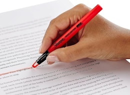 a hand highlighting words on a page