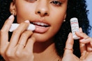 woman applying and holding Aquaphor lip balm
