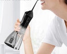 a water flosser on a table plugged into a wall