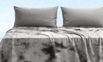 a grey blanket on a bed