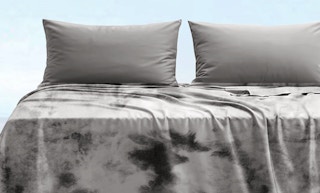 a grey blanket on a bed
