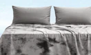 a grey blanket on a bed