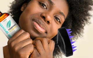 a woman holding a bottle of hair oil and a scalp massage brush