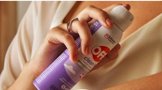 someone spraying insect repellent on their skin