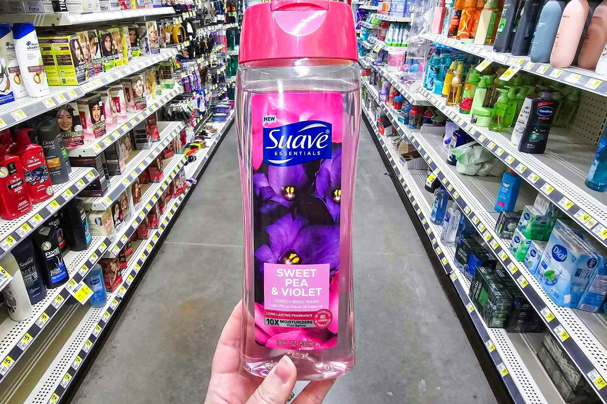 hand holding a bottle of suave essentials body wash at dollar general
