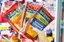 hand holding packs of sargento cheese slices