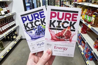 person holding a box of pure kick hydration singles