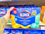hand holding a three pack of clorox wipes on walmart shelf