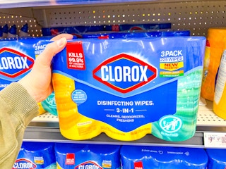 hand holding a three pack of clorox wipes on walmart shelf