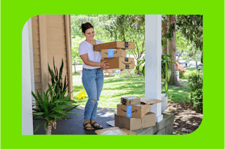 a woman carrying amazon boxes on a porch