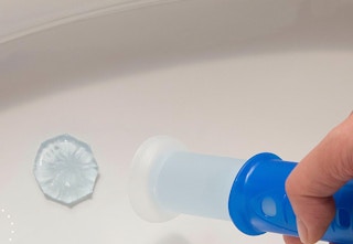a toilet bowl cleaning stamp on a toilet bowl