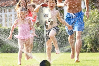 a family playing with a rocket sprinkler toy