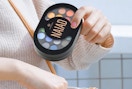 a person putting a makeup palette in their bag 