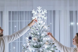 A couple hanging up the Brightown-Christmas-Tree-Topper-Star-Lighted.