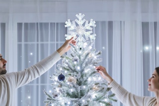 A couple hanging up the Brightown-Christmas-Tree-Topper-Star-Lighted.
