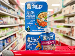 A variety of Gerber food sitting in the top of a store cart.