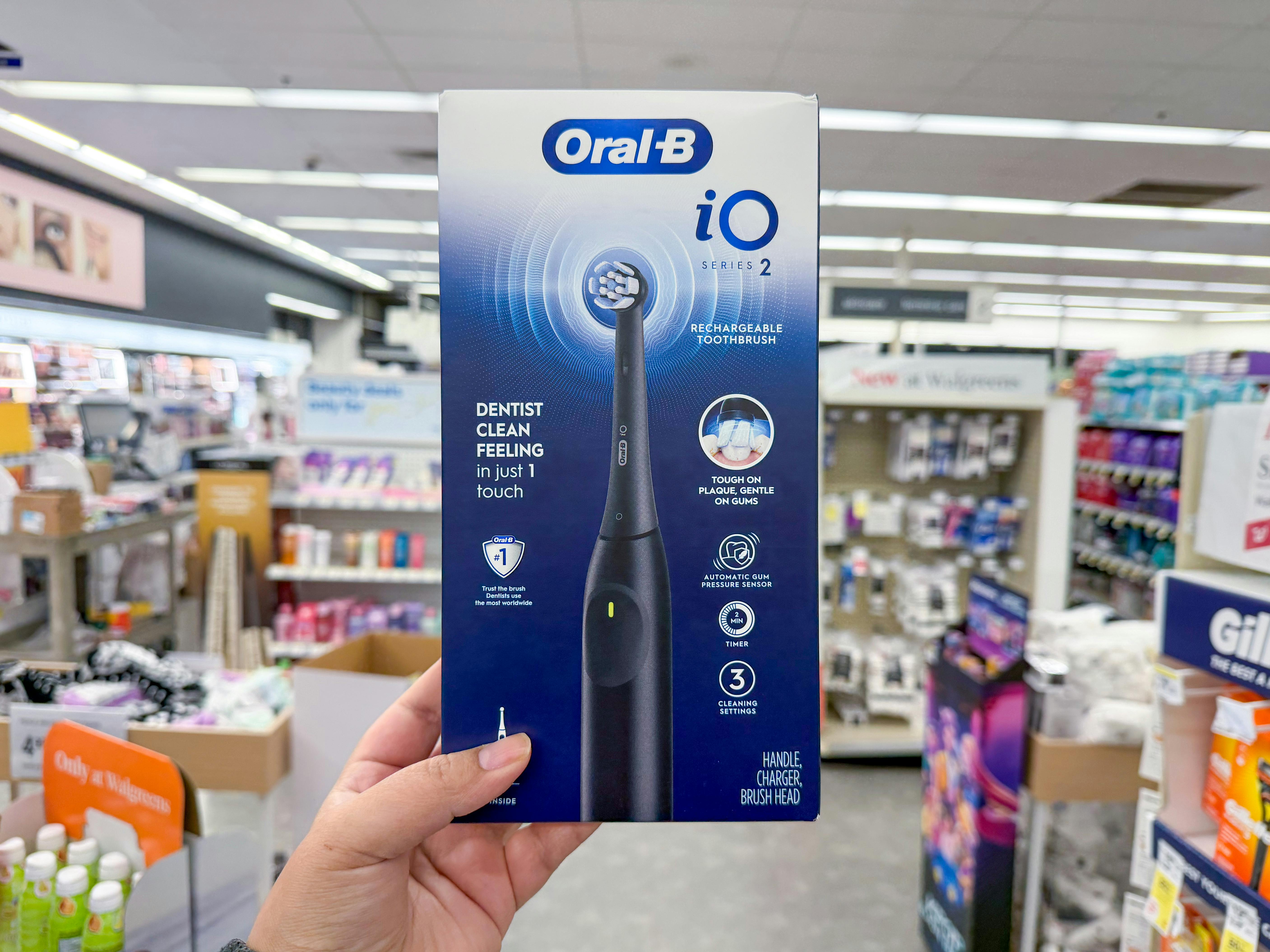 hand holding oral-b electric toothbrush in walgreens