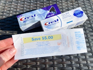 crest premium toothpaste on an outdoor table with a walgreens register reward