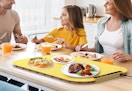 a family eating food at a table with a warming tray