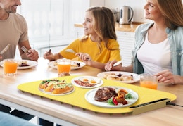 a family eating food at a table with a warming tray