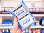 hand holding 2 packs of neutrogena wipes at target