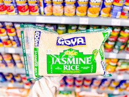 hand holding a bag of goya jasmine rice in walmart aisle