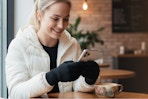 Woman wearing the CozyGalar Winter Gloves while using her smartphone.