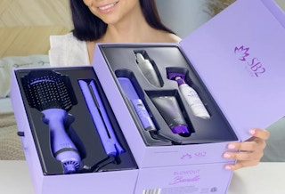 a woman holding a hair blowout set