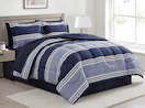 a bed with a blue and white comforter set in a room