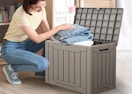 a person putting stuff in a deck box