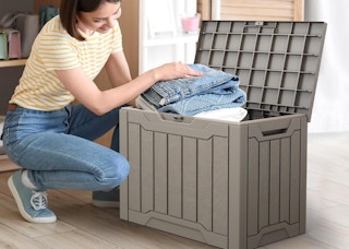 a person putting stuff in a deck box