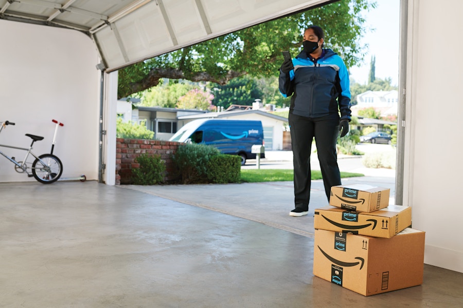 An Amazon delivery driver using the Key for garage delivery option to put Amazon packages inside a garage.