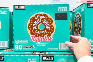 hand touching a box of donut shop k-cups