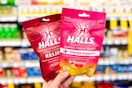 hand holding two bags of halls cough drops