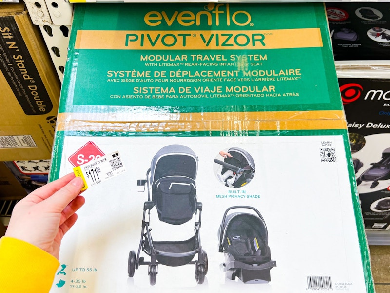 hand holding clearance sign next to Evenflo Travel System at walmart