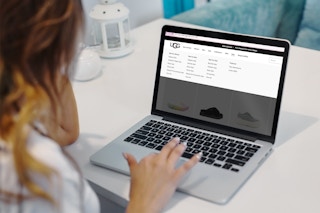 a woman looking at the ugg website on laptop