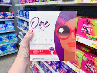box of one by poise liners held in front of walmart shelves