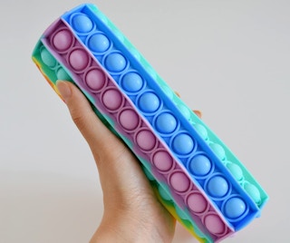 A person holding a pop fidget toy.