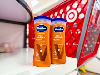 2 vaseline lotion bottles sitting in front a parked target cart