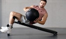 a person working out with a medicine ball on a bench