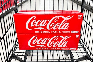 two coca-cola 12-packes in a black shopping cart