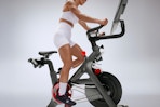 a woman using a peloton cross training bike