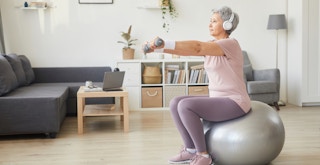 a person on an exercise ball with headphones on