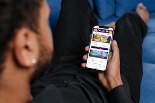 person holding phone looking at Fetch Play in app