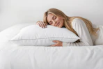 Lifestyle image of a woman sleeping on a pillow