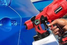 a cordless paint sprayer spraying on a car