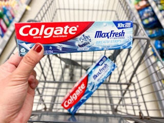 hand holding colgate toothpaste