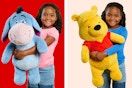 Jumbo plush toys (Eeyore & Pooh Bear from Disney's Winnie the Pooh) held by child