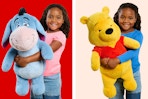 Jumbo plush toys (Eeyore & Pooh Bear from Disney's Winnie the Pooh) held by child